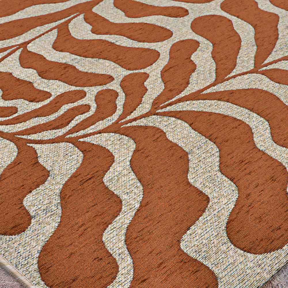 Couristan Castille Indoor/Outdoor Rug - Fiore/Terra-Cotta displays a sweeping leaf-like pattern in terracotta and beige across a flat surface