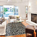 Couristan Castille Indoor/Outdoor Rug - Graffiti/Black-White is placed in a bright living room under a glass coffee table