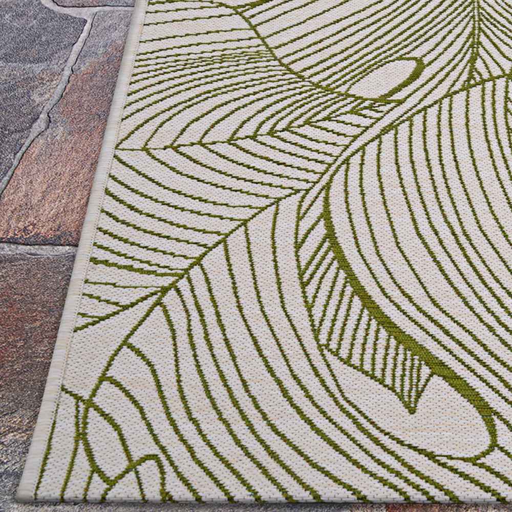 Couristan Castille Indoor/Outdoor Rug - Palma/Fern lies flat on a stone patio floor