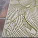 Couristan Castille Indoor/Outdoor Rug - Palma/Fern lies flat on a stone patio floor