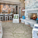 Couristan Castille Indoor/Outdoor Rug - Palma/Rouge lies in a cozy living room with a fireplace, bar, and wood-paneled walls