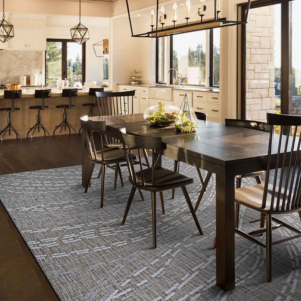 Couristan Charm Indoor/Outdoor Rug - Aurora/Twig is elegantly placed under a dining table in a modern kitchen