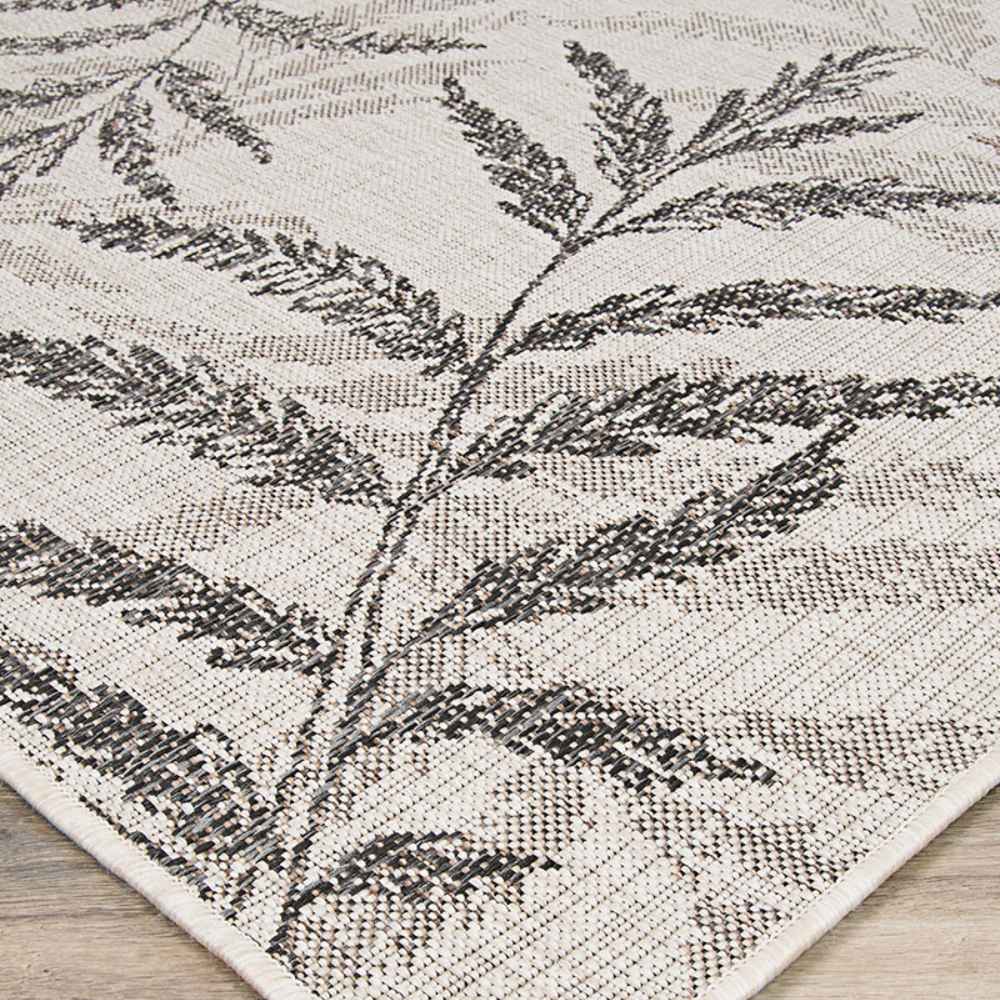 Couristan Charm Indoor/Outdoor Rug - Kimberly/Naturals shows detailed leaves in soft blacks and browns, woven into a light neutral background