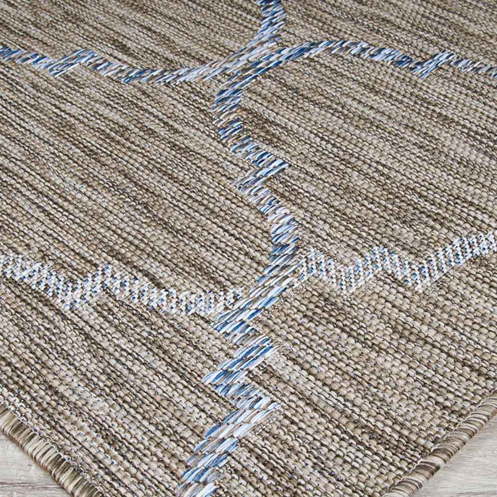 Couristan Charm Indoor/Outdoor Rug - Tiverton/Sand-Ivory features a close-up of its textured weave with a geometric pattern in blue and ivory on a sandy background