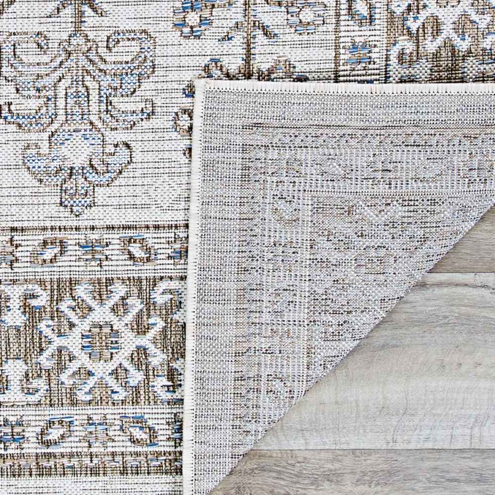 Couristan Charm Indoor/Outdoor Rug - Woodburn/Ivory-Sand is flipped to show the underside, illustrating its flat woven backing and subtle color consistency