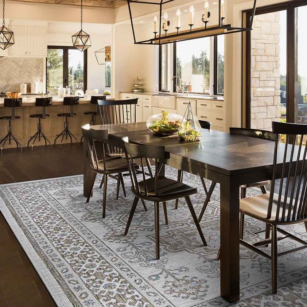 Couristan Charm Indoor/Outdoor Rug - Woodburn/Ivory-Sand is placed under a dining table, blending beautifully with the warm and airy kitchen decor