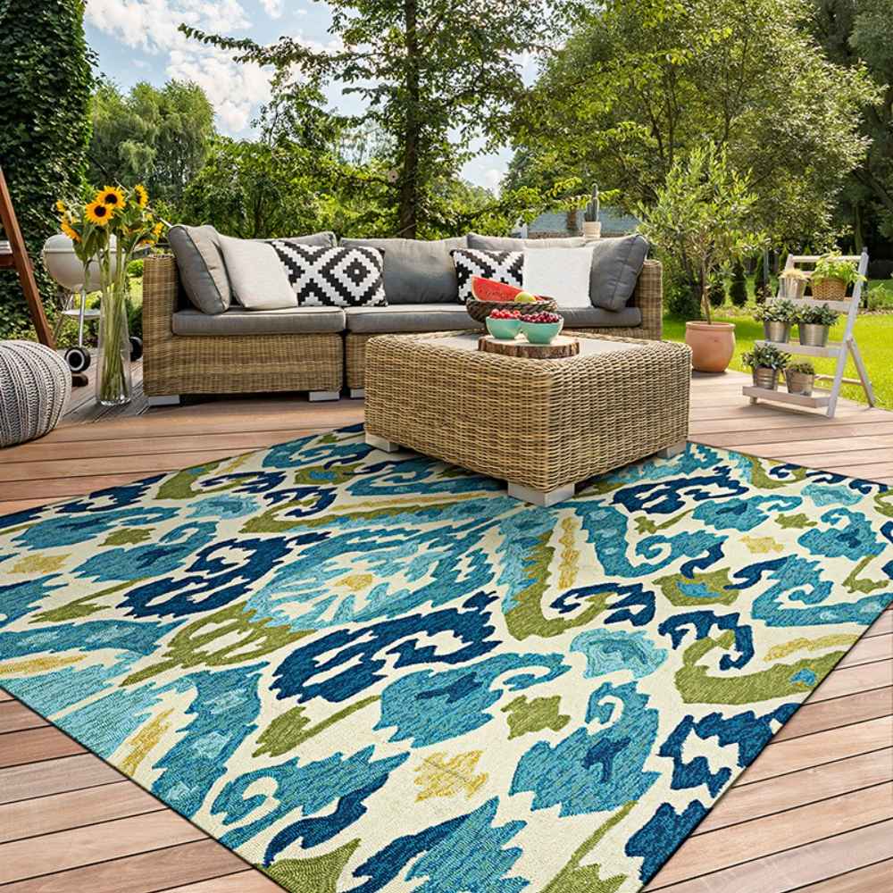 Couristan Covington Indoor/Outdoor Rug - Delfina/Azure-Lemon is placed under a patio coffee table in an outdoor seating area