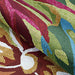 Couristan Covington Indoor/Outdoor Rug - Painted Fern/Fern-Red is partially rolled up, showing its colorful pattern and plush looped construction