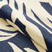 Couristan Covington Indoor/Outdoor Rug - Palms/Navy is partially rolled to showcase its flexible material and tropical leaf pattern