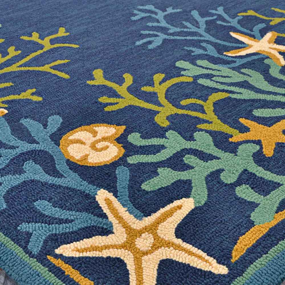 Couristan Covington Indoor/Outdoor Rug - Sea Water/Ocean-Aqua displays colorful sea-inspired patterns like coral and starfish on a rich blue background