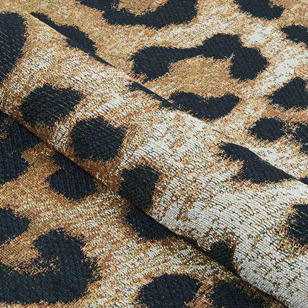 Couristan Dolce Indoor/Outdoor Rug - Amur Leopard/New Gold is rolled up to reveal its tightly woven fabric and thick texture with vivid animal print design