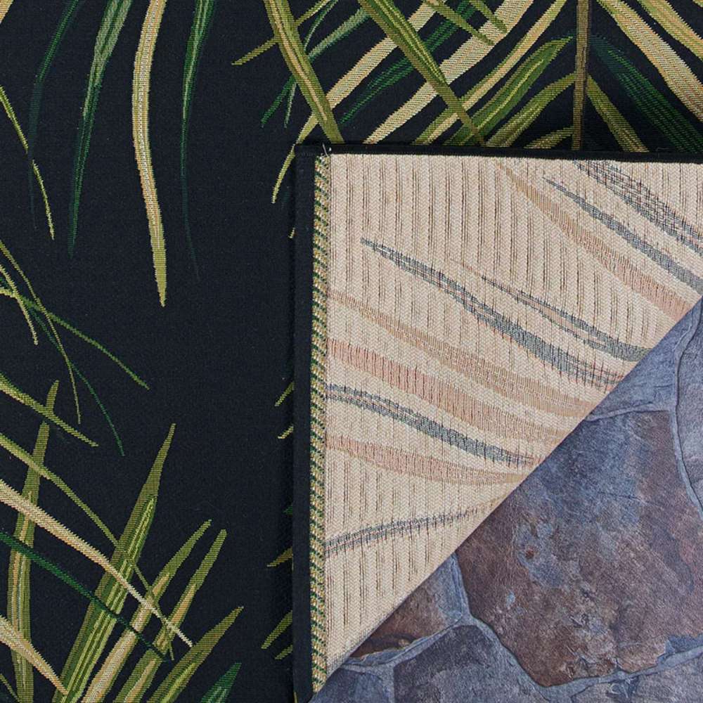 Couristan Dolce Indoor/Outdoor Rug - Bamboo Forest/Cool Onyx is shown from the corner with its underside flipped to reveal the backing and edge stitching