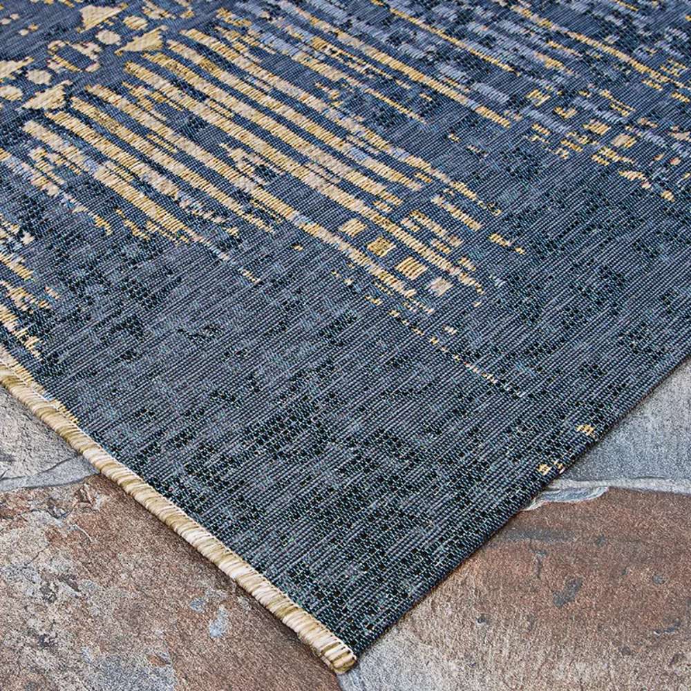 Couristan Dolce Indoor/Outdoor Rug - Blue Nile/Indigo is displayed lying flat on stone tiles
