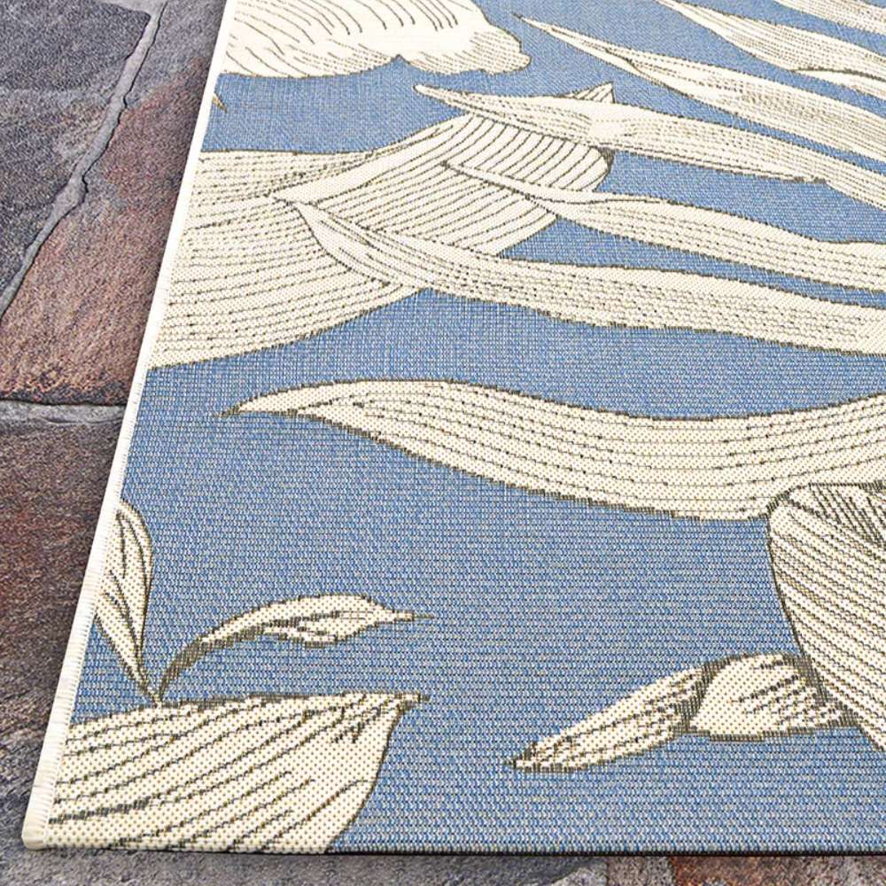 Couristan Dolce Indoor/Outdoor Rug - Flora/Ice is photographed diagonally showing its neat edges and elegant large white flower designs over a soft blue base