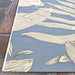 Couristan Dolce Indoor/Outdoor Rug - Flora/Ice is photographed diagonally showing its neat edges and elegant large white flower designs over a soft blue base