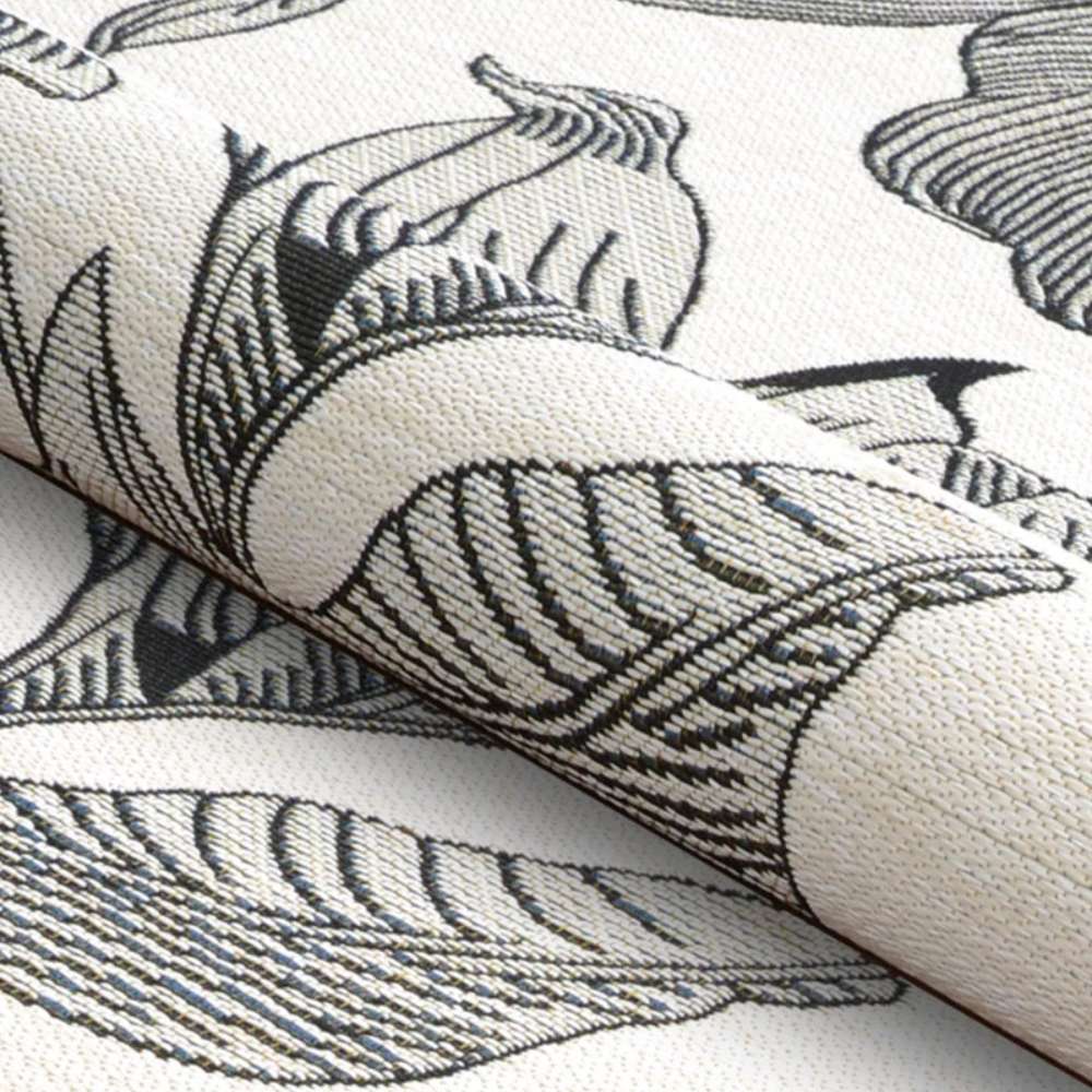 Couristan Dolce Indoor/Outdoor Rug - Flora/Snow is gently rolled to highlight its soft, flexible texture and bold black botanical pattern