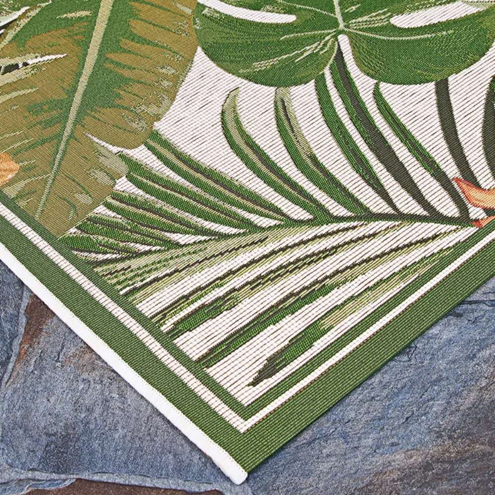 Couristan Dolce Indoor/Outdoor Rug - Flowering Fern/Ivory-Hunter Green shows its crisp corner laid over stone