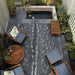 Couristan Dolce Indoor/Outdoor Rug - Hyena/Denim-Silver is beautifully placed in a cozy outdoor patio setting with wooden furniture