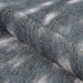 Couristan Dolce Indoor/Outdoor Rug - Hyena/Denim-Silver is partially rolled showcasing its flexibility and thick weave
