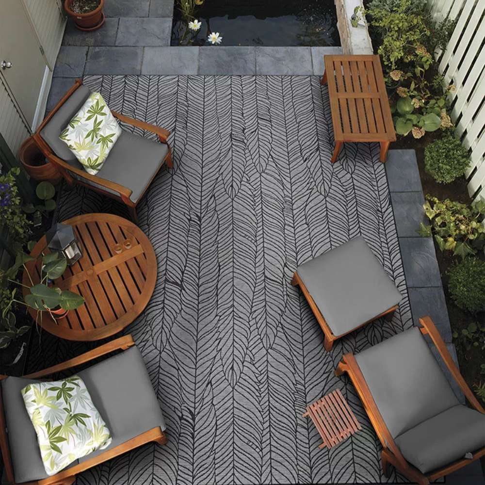 Couristan Dolce Indoor/Outdoor Rug - Majorelle/Silver-Black is placed under outdoor furniture