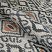 Couristan Dolce Indoor/Outdoor Rug - Mala/Smoke is shown partially folded to display its soft, flexible weave and detailed geometric design