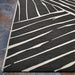 Couristan Dolce Indoor/Outdoor Rug - Parquet/Charcoal displays its crisp linear pattern along the edge in a close-up view