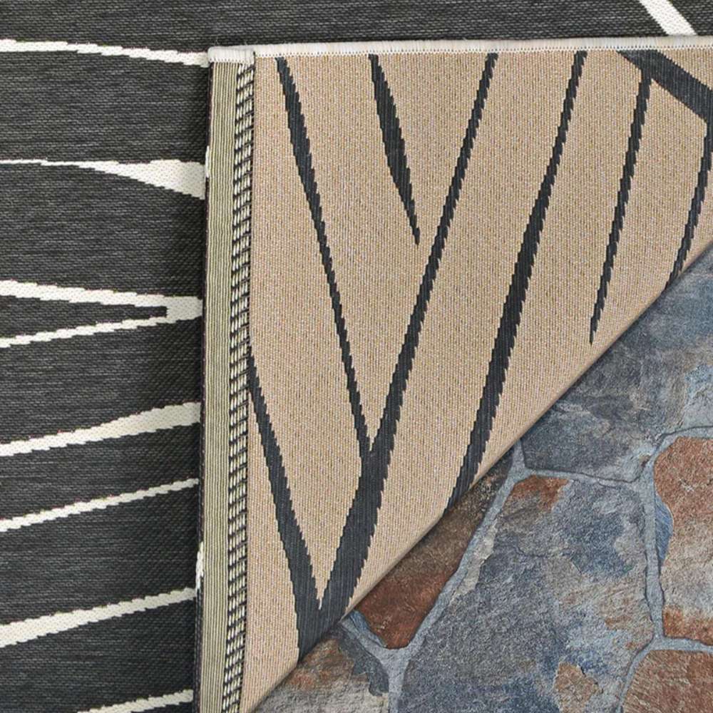 Couristan Dolce Indoor/Outdoor Rug - Parquet/Charcoal is shown with a corner flipped to reveal its reversible beige and charcoal design