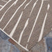 Couristan Dolce Indoor/Outdoor Rug - Parquet/Mocha is shown on a stone patio corner