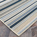 Couristan Dolce Indoor/Outdoor Rug - Striped/Nautical is displayed close-up on a stone surface