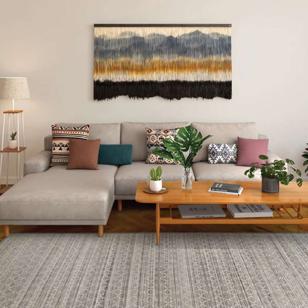 Couristan Fez Indoor/Outdoor Rug - Riad/Ash is styled in a modern living room under a beige sectional sofa and wooden coffee table