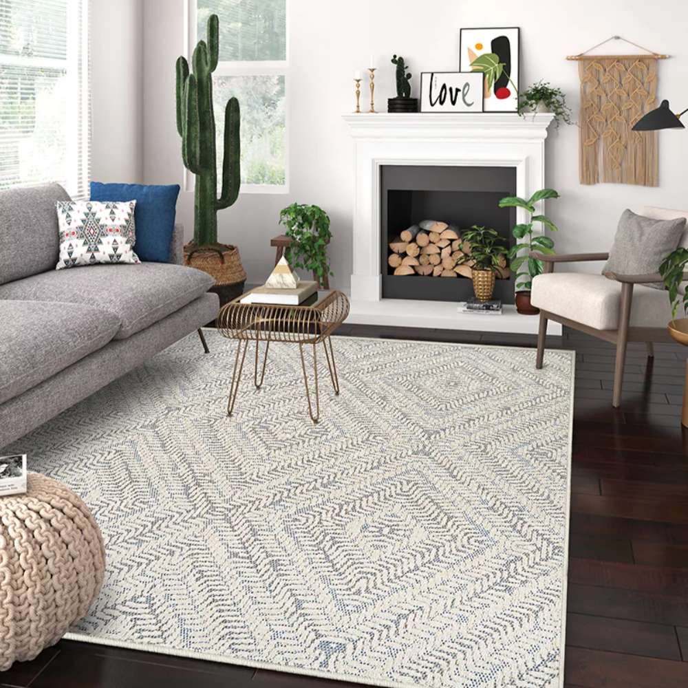 Couristan Liguria Indoor/Outdoor Rug - Levanto/Aqua is styled in a modern living room with a sofa, plants, and a fireplace
