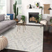 Couristan Liguria Indoor/Outdoor Rug - Levanto/Aqua is styled in a modern living room with a sofa, plants, and a fireplace