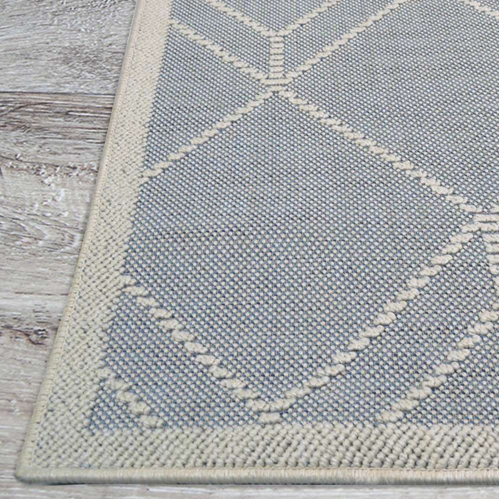 Couristan Liguria Indoor/Outdoor Rug - Noli/Azul displays its elegant edge and ivory-trimmed border lying flat on a wooden floor