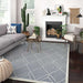 Couristan Liguria Indoor/Outdoor Rug - Noli/Azul is placed in a modern living room with a sofa, fireplace, and plants