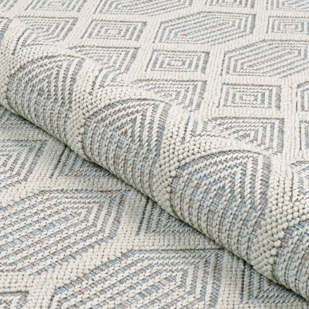 Couristan Liguria Indoor/Outdoor Rug - Rapallo/Aqua is rolled slightly to highlight its flexibility and raised texture