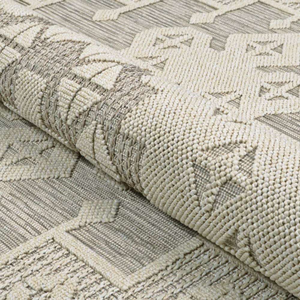 Couristan Liguria Indoor/Outdoor Rug - Sarzana/Dove Grey partially rolled to highlight its flexibility and weave