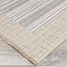 Couristan Monaco Indoor/Outdoor Rug - Bowline/Cocoa Natural-Ivory displays its neat striped edge lying flat on a wooden floor