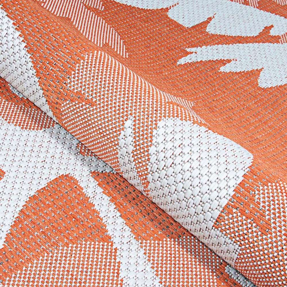 Couristan Monaco Indoor/Outdoor Rug - Coastal Flora/Ivory-Orange is shown folded to emphasize its durable weave and vibrant tropical design