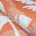 Couristan Monaco Indoor/Outdoor Rug - Coastal Flora/Ivory-Orange is shown folded to emphasize its durable weave and vibrant tropical design