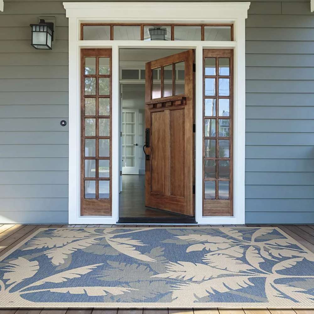 Couristan Monaco Indoor/Outdoor Rug - Coastal Flora/Ivory-Sapphire sits beautifully at a front entryway
