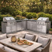 Cozy backyard dining space with string lights and grills showcasing the Sunstone Texas Tango 19ft Outdoor Kitchen Island Package