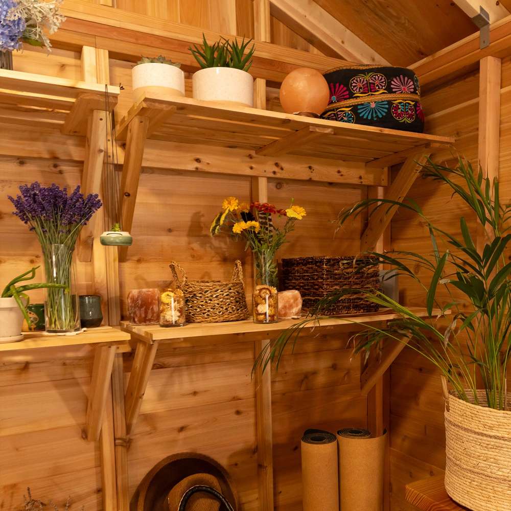 Cozy shed corner displays Outdoor Living Today 8ft Western Red Cedar Shed Shelves (Set of 3) holding potted plants, baskets, and decorative items