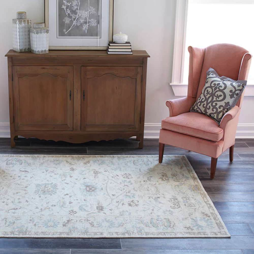 Cozy corner with a wooden cabinet and pink armchair is brightened by Momeni Anatolia Indoor Rug - ANA-5 Beige