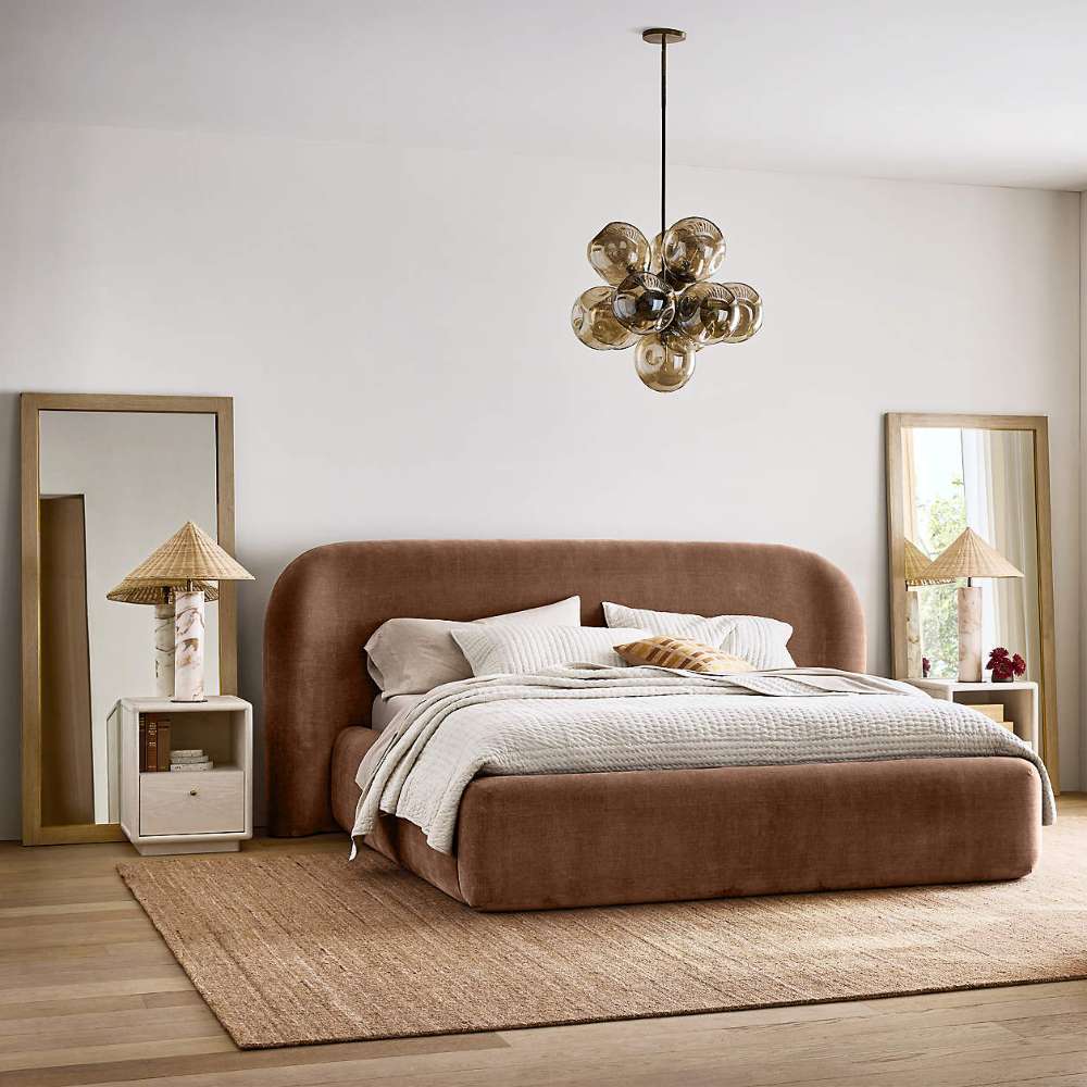Crate & Barrel Adelaide Curved Upholstered Bed styled in a modern bedroom with neutral bedding, wood accents, and soft lighting
