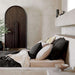 Crate & Barrel Annie 38" Charcoal Brown Storage Cabinet placed beside a bed in a warm, contemporary bedroom