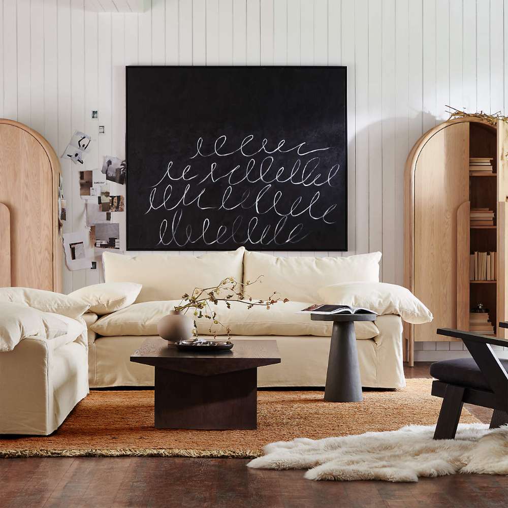 Crate & Barrel Annie 38" Natural Storage Cabinet displayed in a cozy living room with open shelving and decorative accents