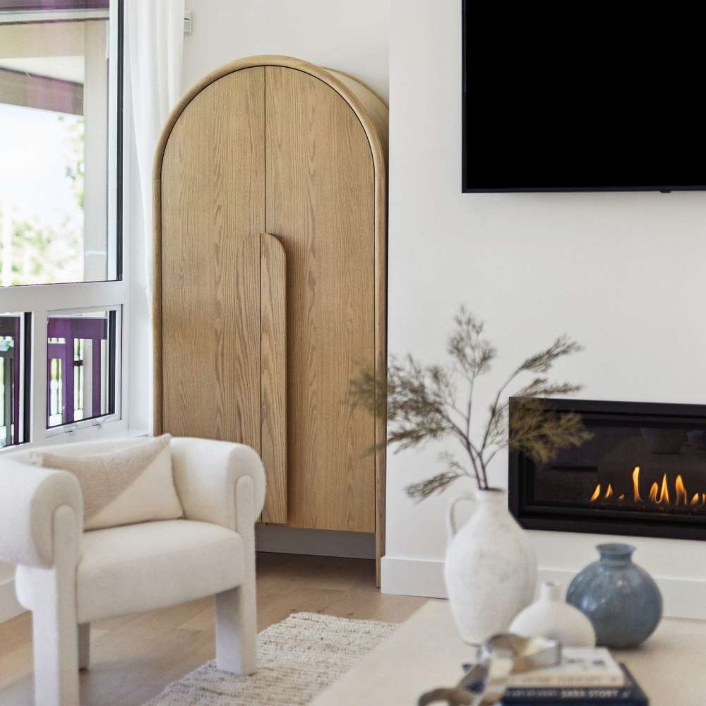 Crate & Barrel Annie 38" Natural Storage Cabinet styled in a living room next to a fireplace and modern seating