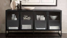 Crate & Barrel Casement 66" Black Credenza displays decorative bowls, books, and accents on two shelves behind smoked glass doors