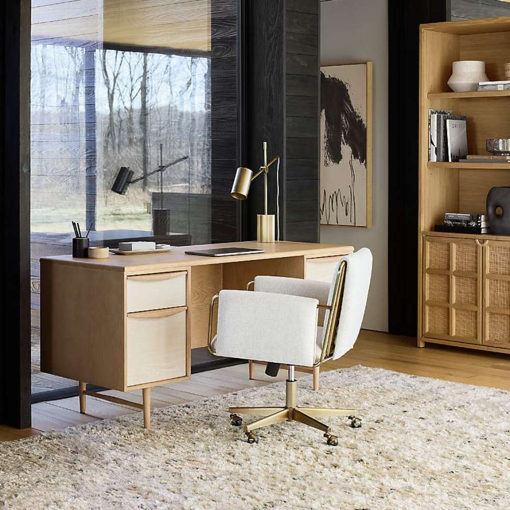 Crate & Barrel Caterina Natural Upholstered Office Chair with Brass Base paired with a light wood desk in a modern workspace with natural textures and warm tones