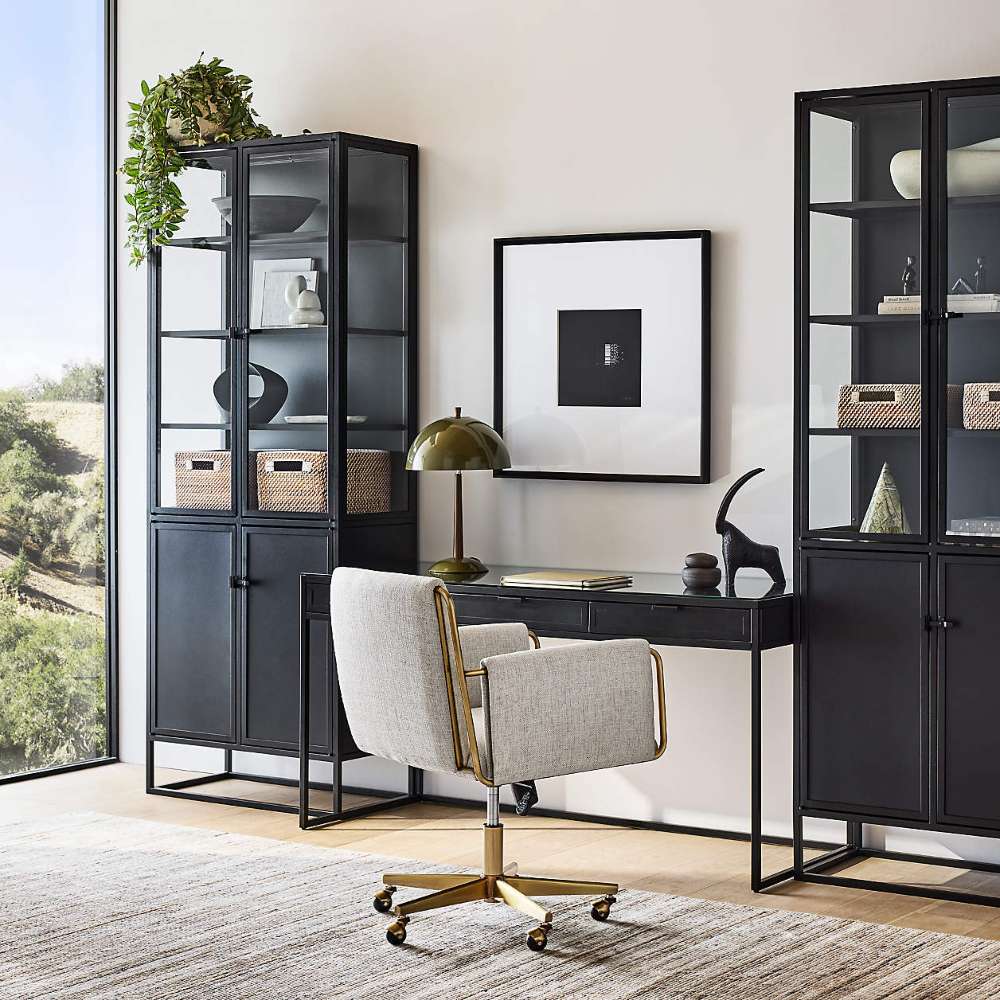 Crate & Barrel Caterina Natural Upholstered Office Chair with Brass Base positioned at a sleek black desk between tall storage cabinets in a contemporary office